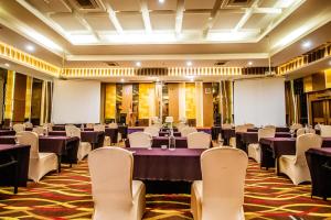 une salle de banquet avec des tables violettes et des chaises blanches dans l'établissement Grand Tjokro Yogyakarta, à Yogyakarta