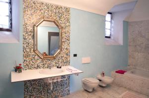 a bathroom with a sink and a toilet and a mirror at Casa della Sofora in Bene Vagienna