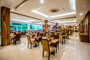 a dining room with tables and chairs in a restaurant at Grand Tjokro Yogyakarta in Yogyakarta