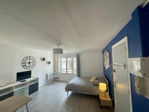 een slaapkamer met een bed en een muur met blauwe accenten bij Moissac Centre appartement indépendant calme cour Intérieure pour vélo 30m2 in Moissac