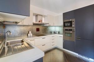 a kitchen with white cabinets and a sink at La Maison du Bonheur Grosio in Grosio