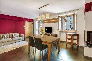 a living room with a wooden table and a couch at La Maison du Bonheur Grosio in Grosio