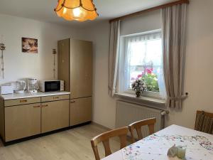 a kitchen with a table and a window at Haus Beate, FeWo im Bienenparadies in Kirchberg