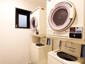 a laundry room with a washing machine and a washer at HOTEL LiVEMAX Osaka Dome Mae Hotel in Osaka +11 photos