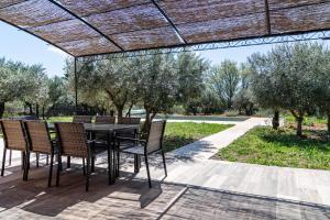 a patio with a table and chairs under a pergola at Dathona - Charmante maison avec piscine est jardin in Aups