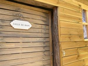 een bord aan de zijkant van een houten gebouw bij chambre double avec salle de bain privée in Monacia-dʼAullène