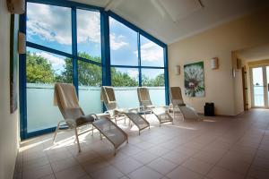a waiting room with chairs and a table and windows at JUFA Hotel im Brückenkopfpark - Jülich in Jülich