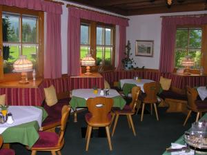 a restaurant with two tables and chairs and windows at Pension Köberl in Bad Mitterndorf