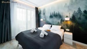 une chambre avec deux lits avec des serviettes dessus dans l'établissement Wonder Home - Apartamenty Karpatia Resort tuż przy stoku i blisko szlaków turystycznych, à Karpacz
