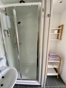 La salle de bains est pourvue d'une douche et d'un lavabo. dans l'établissement The Retreat holiday apartment, à Polperro