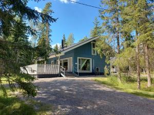 a blue house with a driveway at Fishing and holiday village Merikoivula in Uusikaupunki