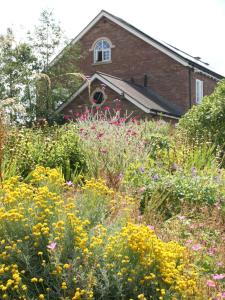 a garden with flowers in front of a building at The Mooring Post in Gloucester