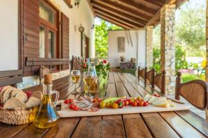 a table with a plate of food and glasses of wine at Villa Štrkalj ZadarVillas in Murvica