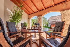 an outdoor dining room with a table and chairs at Villa Štrkalj ZadarVillas in Murvica