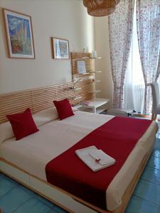 a bedroom with a large bed with a red blanket at B&B FLAVIO in Pozzuoli