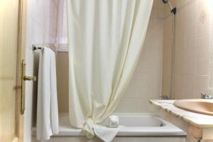 a bathroom with a shower and a sink and a tub at Apartamentos Park Plaza in Puerto de la Cruz