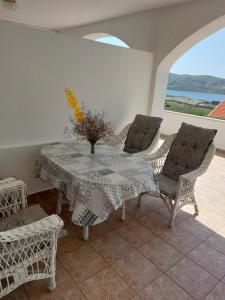 a dining room with a table and chairs and a window at Apartments Markulincic in Novalja