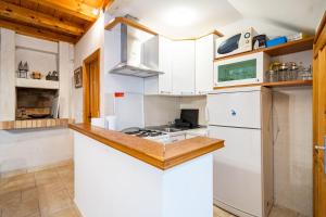 a kitchen with white cabinets and a white refrigerator at Studio Apartment Pupa in Dubrovnik