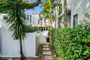 a palm tree in front of a white building at Las Olas Hammocks Unit 3 By Pmi in Fort Lauderdale