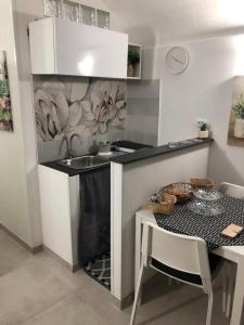 a small kitchen with a sink and a table with a tableablish at Casa Cavour in Noto