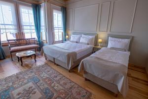 - une chambre avec deux lits et une chaise dans l'établissement İkiz Konak Boutique Hotel, à Istanbul