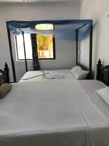 two beds in a room with a window at Tayana place in Kizimkazi +35 photos