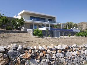 a house with a stone wall in front of it at MIROS MARE STUDIOS in Agia Galini