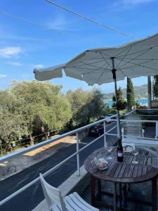 einen Tisch mit Sonnenschirm und Stühlen auf dem Balkon in der Unterkunft Monolocale Baia dei Delfini in Porto Venere