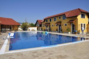 a large swimming pool in front of two buildings at Motel Alaska in Deva