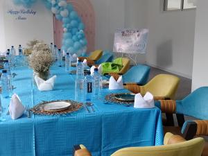 une longue table avec un chiffon de table bleu et des ballons dans l'établissement Muthu Warwick Mount Kenya Hotel, Nanyuki, à Nanyuki