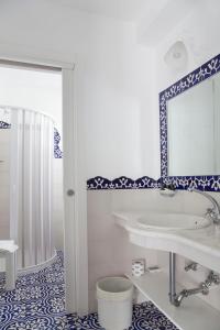 a bathroom with a tub and a sink and a mirror at Hotel La Terrazza in Panarea