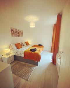 a bedroom with a bed with an orange blanket at Kings Mile House in Canterbury