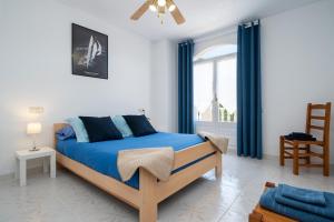 a bedroom with a bed with blue sheets and a window at Apartamento Aigua Blava in L'Ampolla