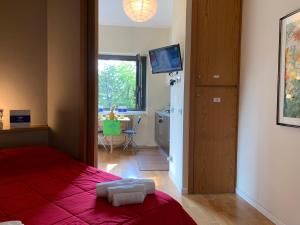 - une chambre avec un lit doté d'une couverture rouge et d'une table dans l'établissement House Marittima by Holiday World, à Gênes