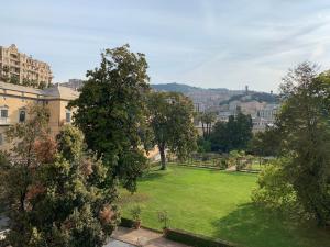 un parc verdoyant avec des arbres et des bâtiments en arrière-plan dans l'établissement House Marittima by Holiday World, à Gênes