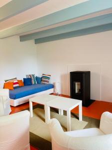ein Wohnzimmer mit einem blauen Sofa und einem Tisch in der Unterkunft Maison de charme entre terre et mer, proche plages in Névez