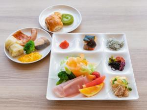 ein Tablett mit verschiedenen Arten von Lebensmitteln auf einem Tisch in der Unterkunft LiVEMAX RESORT Atami Sea Front in Atami