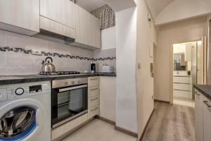 a kitchen with a washer and dryer at MACHIN 57 - Magnolia Holidays in Alghero