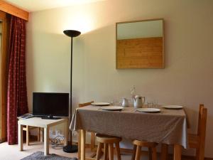 uma mesa de jantar com cadeiras e uma televisão em Appartement Méribel, 1 pièce, 4 personnes - FR-1-180-18 em Méribel