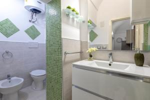 a bathroom with a sink and a toilet and a mirror at MACHIN 57 - Magnolia Holidays in Alghero