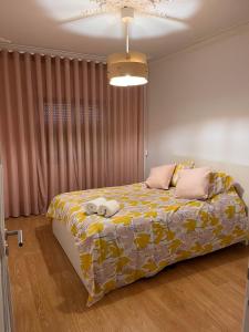 um quarto com uma cama com um cobertor amarelo e rosa em Condomínio Del Rey em Charneca