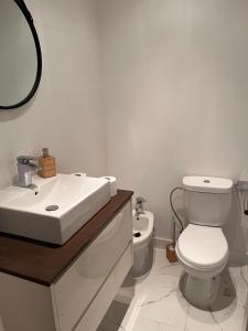 a white bathroom with a sink and a toilet at Condomínio Del Rey in Charneca