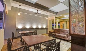 - une salle à manger avec une table, des chaises et un canapé dans l'établissement Treebo Trend Seabreeze Comforts, à Visakhapatnam
