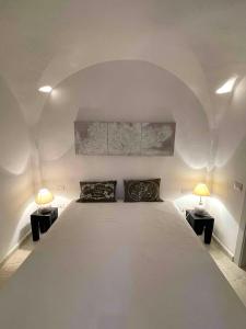 ein Schlafzimmer mit einem großen weißen Bett mit zwei Lampen in der Unterkunft SAN TEODORO PUNTA EST CURATISSIMO BILOCALe in Capo Coda Cavallo