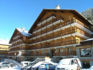 a large building with cars parked in front of it at Appartement 3 pièces avec balcon et WIFI à 150m des pistes, 6 personnes - Méribel - FR-1-180-155 in Méribel