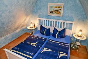 um quarto com paredes azuis e uma cama com lençóis azuis em Ferienwohnung STRANDGUT em Kühlungsborn