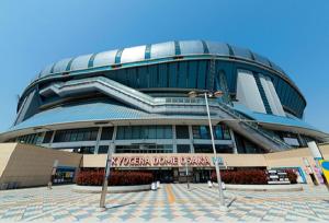 a large building with escalators in front of it at HOTEL LiVEMAX Osaka Dome Mae Hotel in Osaka