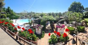 einen Garten mit Blumen in Töpfen neben einem Pool in der Unterkunft Piccolo Feudo Green Resort in Viterbo