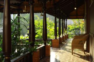 eine Veranda eines Hauses mit einem Stuhl und Pflanzen in der Unterkunft Broad Bean Resort & Spa in Munnar