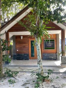 a building with a tree in front of it at The Temak Villa in Pantai Cenang